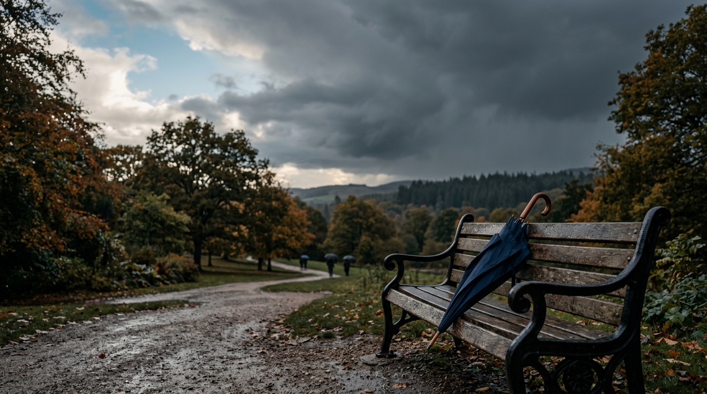 An umbrella leaning on a park bench under a sky that is half blue and half grey